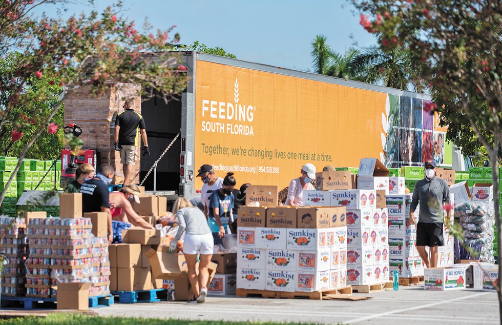 Volunteers preparing food at a food distribution at the Palm Beach Outlets in West Palm Beach on July 21, 2020.jpg