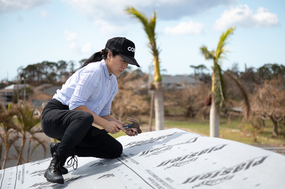Ann Lee tarps a roof near Fort Myers, Florida during the initial phase of COREΓÇÖs response to Hurricane Ian in 2022.  Jeff Tabb for CORE.jpg